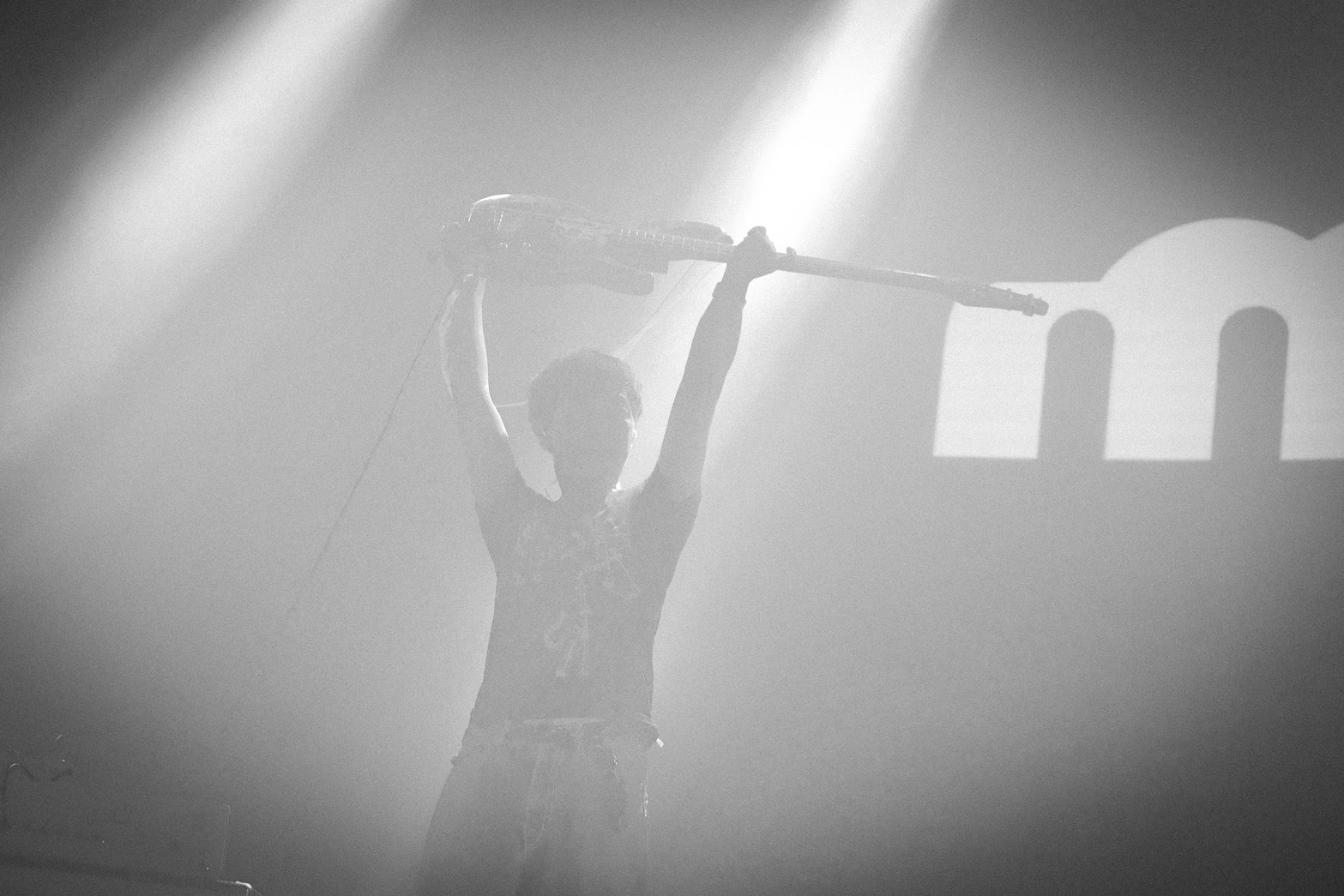 moja bassist raising a bass above the stage